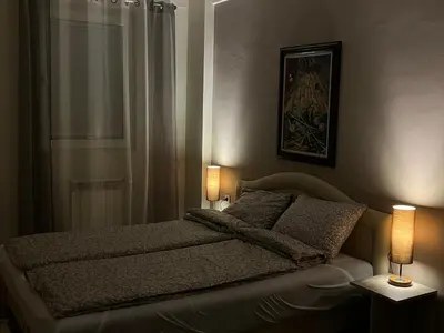 a bedroom with a bed and two lamps on tables at Central Apartments in Zaječar