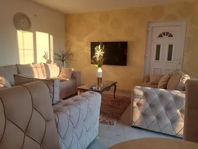 a living room with two couches and a door at DINA LUX Apartman in Jagodina