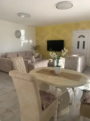 a living room with a table and a couch at DINA LUX Apartman in Jagodina