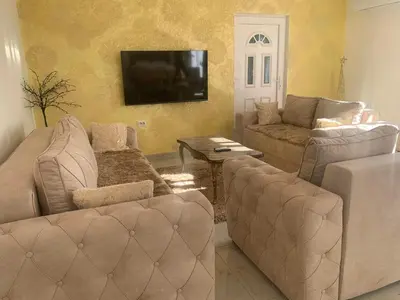 a living room with couches and a flat screen tv at DINA LUX Apartman in Jagodina