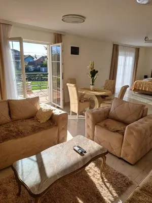 a living room with a couch and a table at DINA LUX Apartman in Jagodina