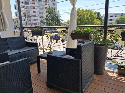 a balcony with chairs and tables on a balcony at DINA LUX Apartman in Jagodina
