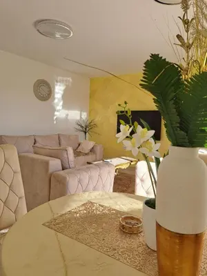 a living room with a couch and a table with a vase at DINA LUX Apartman in Jagodina