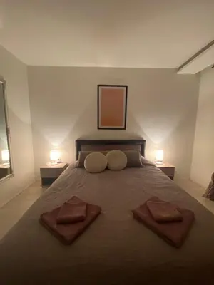 a bedroom with a large bed with two towels on it at Apartman Rose in Kruševac