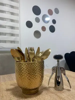 a metal bucket of utensils sitting on a table at Apartman Rose in Kruševac