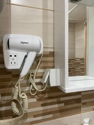 a hair dryer in a bathroom with a mirror at Apartman Rose in Kruševac