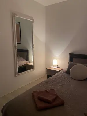 a bedroom with a bed and a large mirror at Apartman Rose in Kruševac