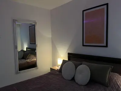 a bedroom with a bed and a large mirror at Apartman Rose in Kruševac