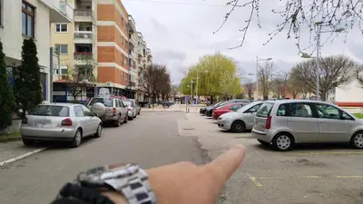 a hand pointing at a street with parked cars at Lela's home (Lelin dom) in Knjazevac.