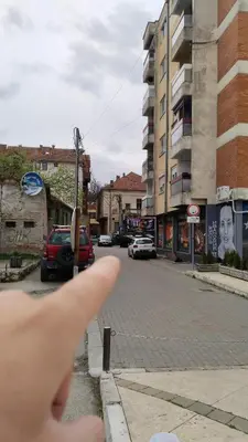 a persons index finger pointing at an empty street at Lela's home (Lelin dom) in Knjazevac.