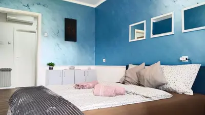 a bedroom with a bed with a blue wall at Lela's home (Lelin dom) in Knjazevac.