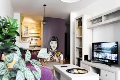 a living room with a painting of a woman at La Maison in Niš