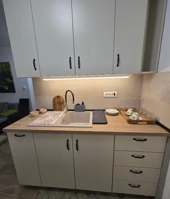 a kitchen with white cabinets and a sink at Anikaapartmani, Brzeće in Brzeće