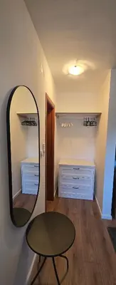 a mirror in a room with a table and a stool at Anikaapartmani, Brzeće in Brzeće