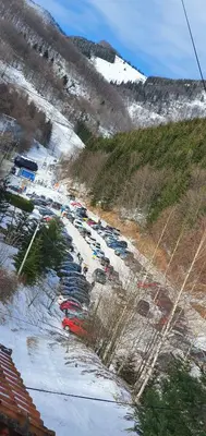 a parking lot with cars parked in the snow at Anikaapartmani, Brzeće in Brzeće