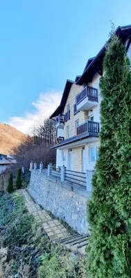 a large white house with a stone wall at Anikaapartmani, Brzeće in Brzeće