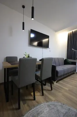 a living room with a couch and a table and chairs at King apartments Kopaonik in Kopaonik