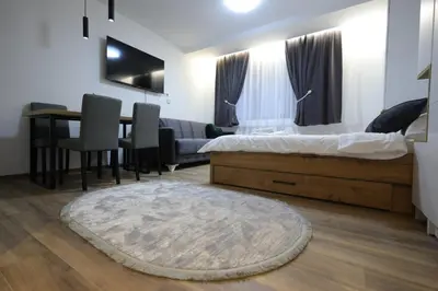 a bedroom with a bed and a dining room at King apartments Kopaonik in Kopaonik