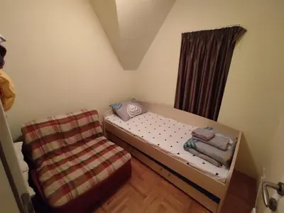 a small bedroom with a bed and a chair at Apartman Sofija Kraljevi Čardaci in Kopaonik