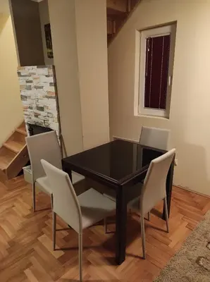a dining room with a black table and chairs at Apartman Sofija Kraljevi Čardaci in Kopaonik
