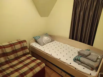a small bedroom with a bed and a chair at Apartman Sofija Kraljevi Čardaci in Kopaonik
