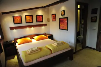 a bedroom with a large bed with yellow pillows at B&B Galerija Two Rooms in Paraćin