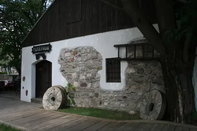 a stone building with a door and a tree at B&B Galerija Two Rooms in Paraćin