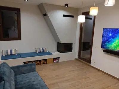 a living room with a couch and a flat screen tv at FlowHouse - cozy place for you. in Kopaonik