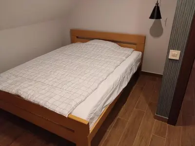 a bedroom with a bed with a wooden headboard at FlowHouse - cozy place for you. in Kopaonik