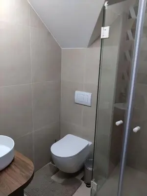 a bathroom with a toilet and a glass shower at FlowHouse - cozy place for you. in Kopaonik
