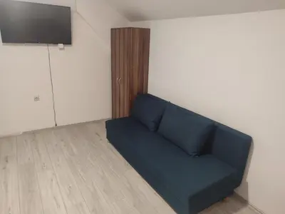 a blue couch in a room with a flat screen tv at Apartmani Hub in Niš