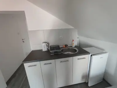 a small kitchen with a sink and a counter at Apartmani Hub in Niš
