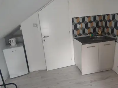 a small kitchen with white cabinets and a sink at Apartmani Hub in Niš