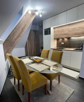 a kitchen and dining room with a table and chairs at SKY PEAK KRALJEVI ČARDACI APARTMENT in Kopaonik