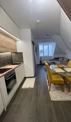 a kitchen and dining room with a table and yellow chairs at SKY PEAK KRALJEVI ČARDACI APARTMENT in Kopaonik