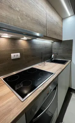 a kitchen with a stove and a sink at SKY PEAK KRALJEVI ČARDACI APARTMENT in Kopaonik