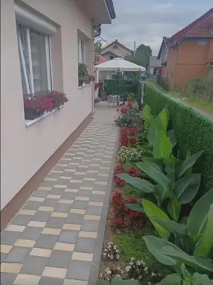 a walkway next to a house with flowers and plants at Apartman Nedeljković in Vrnjačka Banja