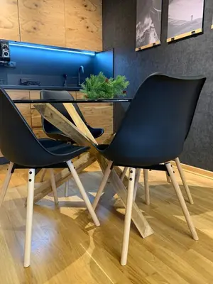a dining table with two black chairs in a room at Apartman Kiš Kraljevi Čardaci in Kopaonik
