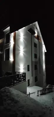 a building in the snow at night with lights at Glečer Kop A11 FREE Parking Garage in Kopaonik