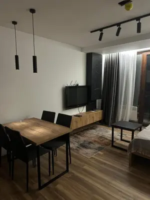 a living room with a wooden table and a television at Apartment KopaLux in Kopaonik