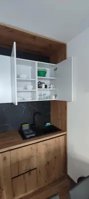 a kitchen with white cabinets and a sink at Apartment KopaLux in Kopaonik
