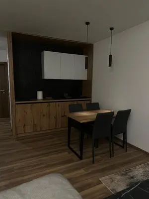 a dining room with a table and a flat screen tv at Apartment KopaLux in Kopaonik