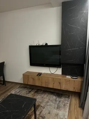 a living room with a flat screen tv on a wall at Apartment KopaLux in Kopaonik