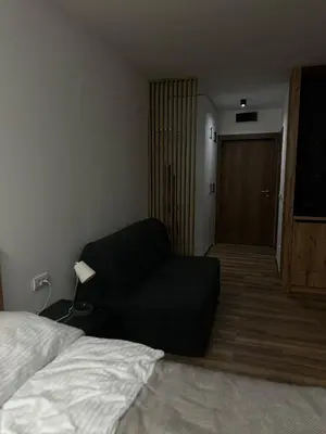a living room with a couch next to a bed at Apartment KopaLux in Kopaonik