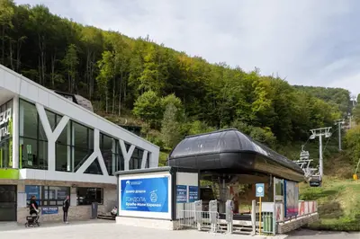 a building in front of a mountain with a ski lift at Studio Joanna Vila Bela Reka in Brzeće