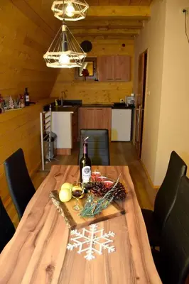 a dining room table with a bottle of wine on it at Brvnare Todorovic in Crni Vrh