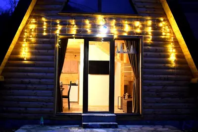 a house with a door with lights on it at Brvnare Todorovic in Crni Vrh