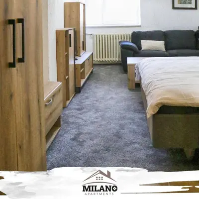 a hotel room with two beds and a couch at Milano Apartman **** in Brzeće