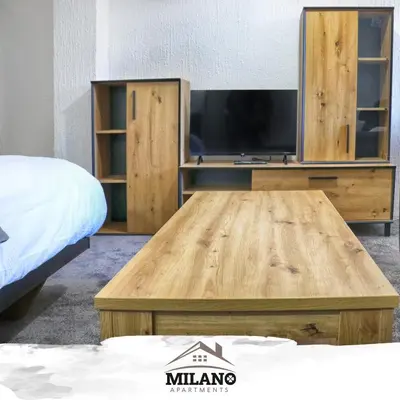 a wooden coffee table with a tv in a bedroom at Milano Apartman **** in Brzeće