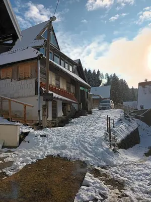 a snow covered street in front of a building at KopanikSkiRooms15e in Kopaonik